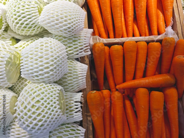 Fototapeta Fresh Vegetables Displayed in Market with Carrots and Cabbages
