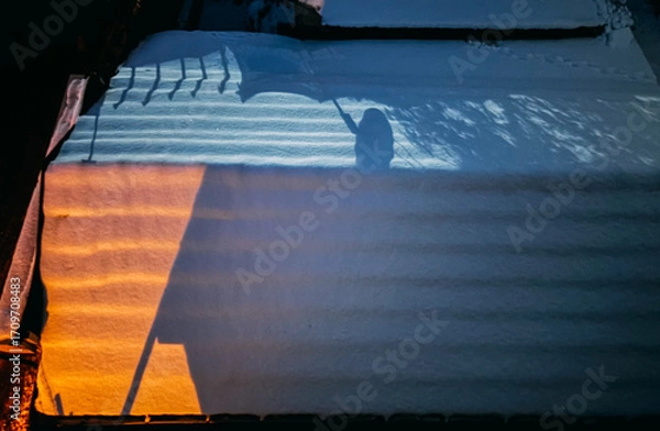 Fototapeta Abstract Shadow of a Person with an Umbrella on Snow at Sunset