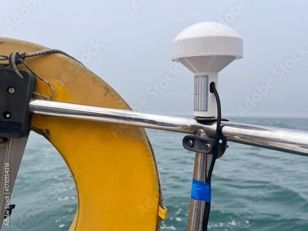 Fototapeta A GPS receiver aerial located to the top of the pushpit of a sailing yacht, used to provide latitude and longitude information to navigation instruments like chartplotters, logs and radar