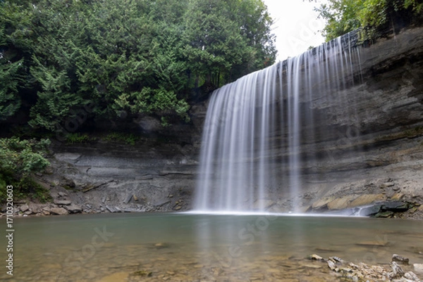 Obraz Bridal Veil Falls on Manitoulin Island offers a serene and picturesque glimpse into Ontario's natural beauty with its cascading waters and lush surroundings.