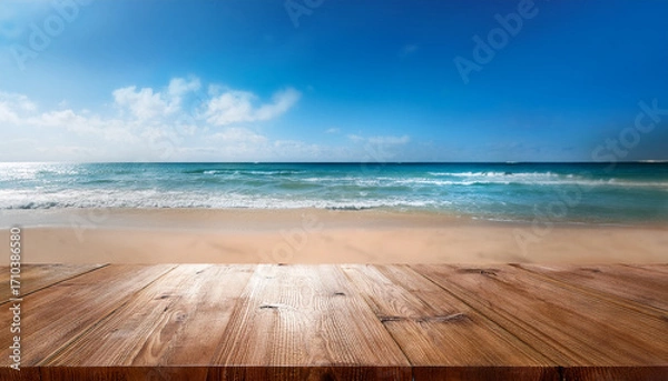 Fototapeta Wooden Table Surface With A Blurred Background Of Sparkling Ocean Waves Sandy Beach And A Bright Blue Sky With Scattered Clouds On A Sunny Day
