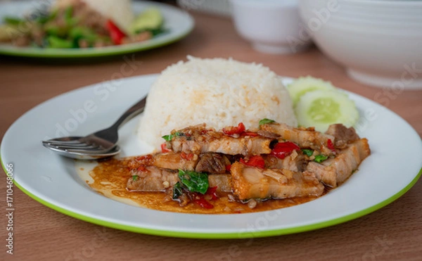 Fototapeta Close up and selective focus stir-fried crispy pork belly and basil with rice - Asian local street food style