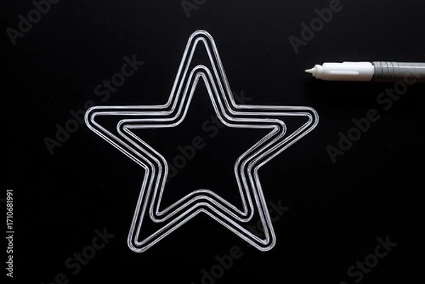 Fototapeta Clear star-shaped outline on a black background with a silver pen for creative design use