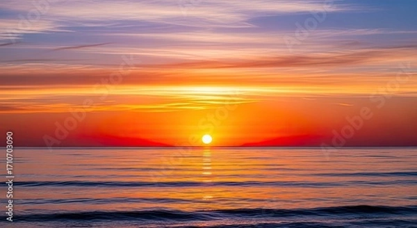 Fototapeta Golden Sunset Over Calm Ocean Waves with Vibrant Sky Reflected on Water