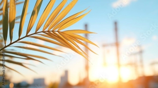 Fototapeta Sunny Palm frond and Power Plant: A close-up of a vibrant palm frond is backlit by the warm rays of the sun, set against a blurred backdrop of a power plant, symbolizing harmony and nature and energy