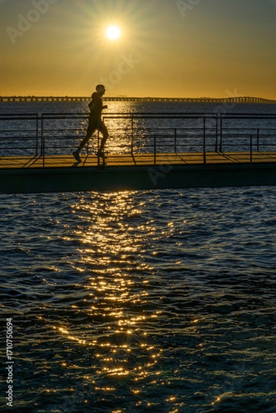Fototapeta A man running early in the morning in Lisbon