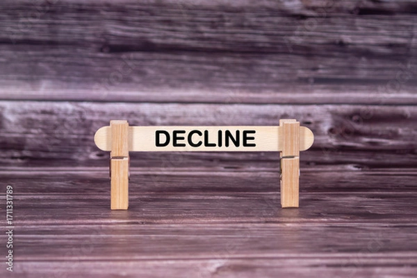 Fototapeta Decline symbol. Wooden stick held by Clothespins, beautiful Realistic Grunge Wooden Background. Business and Decline concept with copy space