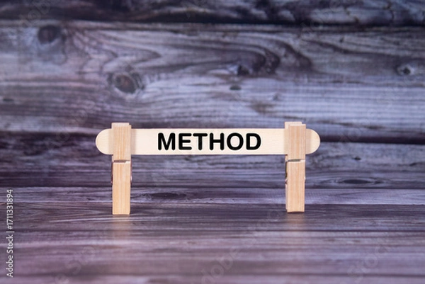 Fototapeta Method symbol. A wooden stick secured by Clothespins set over beautiful Realistic Wooden Texture Background. Business and Method concept with copy space