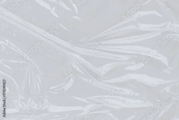 Fototapeta Crinkled clear plastic wrap on bright surface. Suitable for ecofriendly packaging concepts, minimalistic design illustrations, and textures for digital projects.