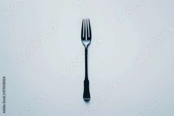 Obraz A simple black fork placed on a light background, emphasizing its design and function.