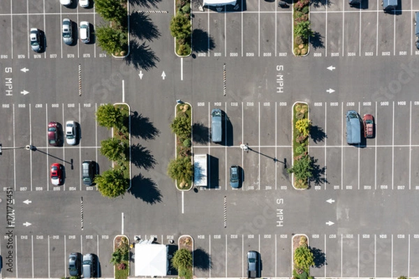 Fototapeta Aerial drone top down view of a large parking lot in a busy shopping and industrial district in Portland, Oregon, showing organized rows, parked cars, and urban commercial infrastructure