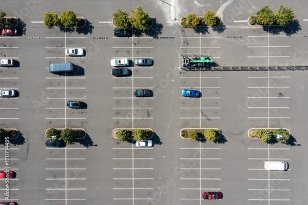 Fototapeta Aerial drone top down view of a large parking lot in a busy shopping and industrial district in Portland, Oregon, showing organized rows, parked cars, and urban commercial infrastructure