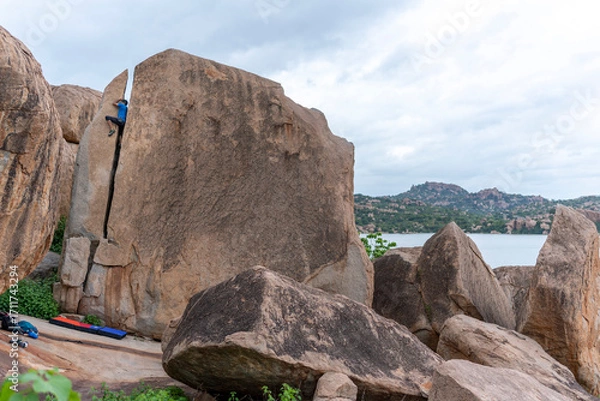 Obraz A rock climber climbing through the crack in Hampi.