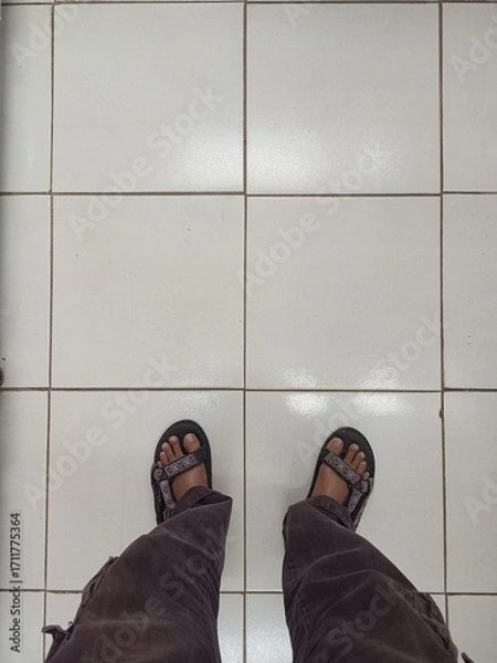 Fototapeta Person standing on a clean white tiled floor