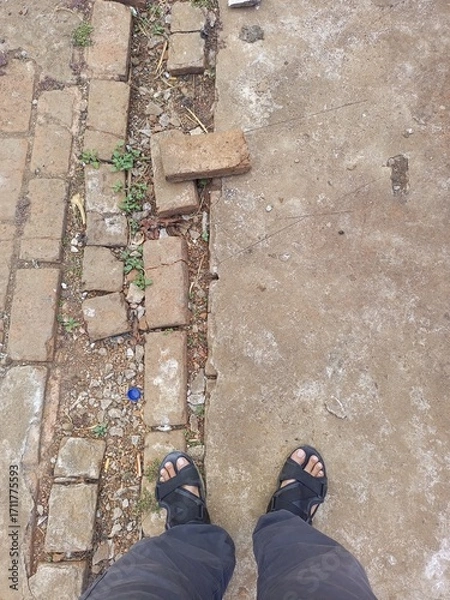 Fototapeta A person standing on two different ground textures