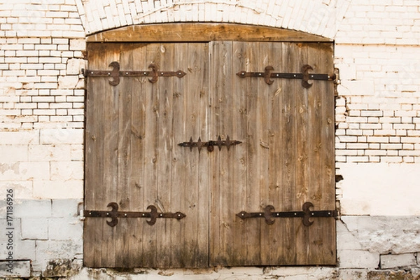 Fototapeta Aged Old Wooden Door With Lock On Old Brick White Wall. Ancient Style.