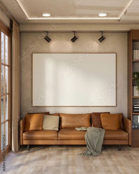 Fototapeta Empty frame with spotlight over brown leather sofa with cushions and blanket on wooden parquet floor.