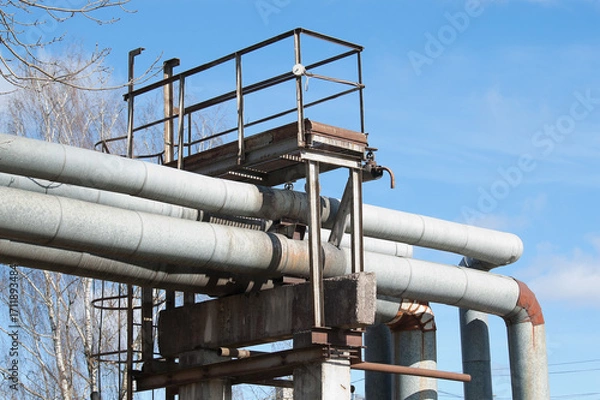 Fototapeta pipeline on concrete supports against blue sky