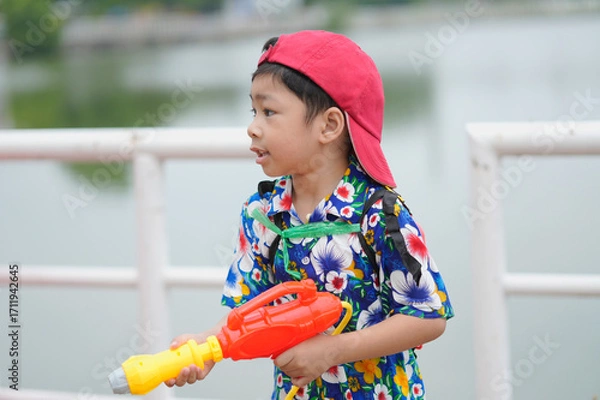 Obraz Children playing Songkran use water guns.