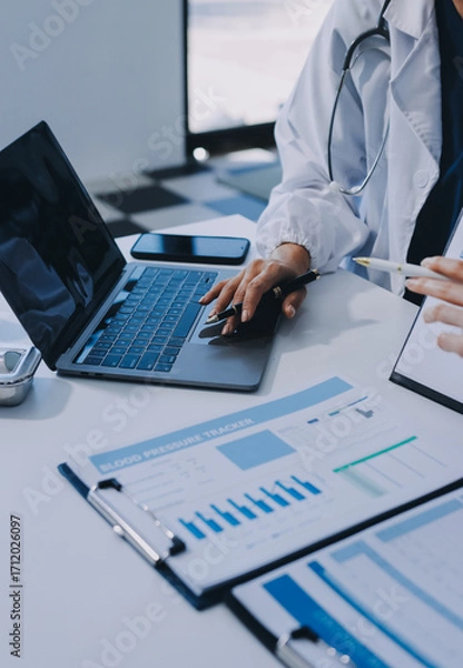Fototapeta Medical team meeting analyzing blood test results in hospital laboratory. Doctors and scientists in lab coats are having a discussion about blood test result, holding test tubes and taking notes.