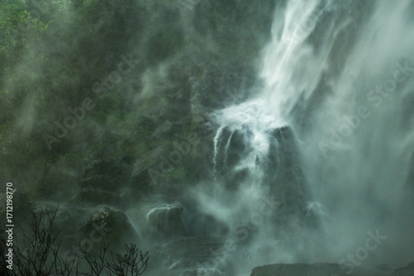 Fototapeta A waterfall with mist and fog in the background 𝙆𝙝𝙡𝙤𝙣𝙜 𝙇𝙖𝙣 waterfall , 𝙆𝙖𝙢𝙥𝙝𝙖𝙚𝙣𝙜 𝙋𝙝𝙚𝙩