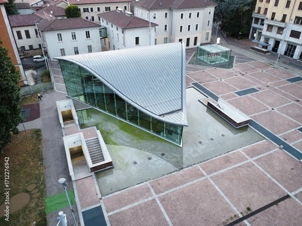 Fototapeta Foto aerea dell’Auditorium pubblico di Seregno, situato nel cuore della città lombarda. L’immagine cattura l’edificio moderno e funzionale e l’architettura contemporanea.
