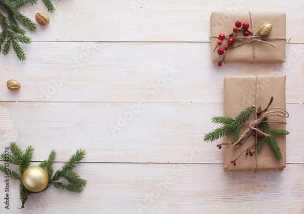 Fototapeta Christmas gift boxes and fir tree branch on wooden table, flat lay