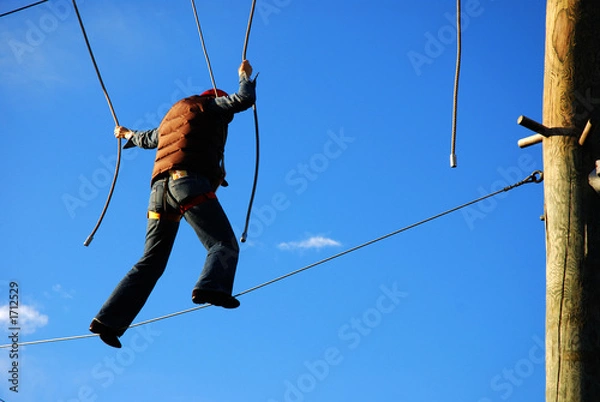 Obraz courageous woman standing on a steel wire