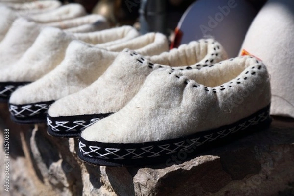Obraz Albanian handicraft products in a souvenir shop in Kruje, Albania. Wool felt slippers.