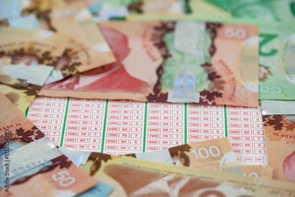 Obraz Close up of lottery ticket with Canadian dollar banknotes.