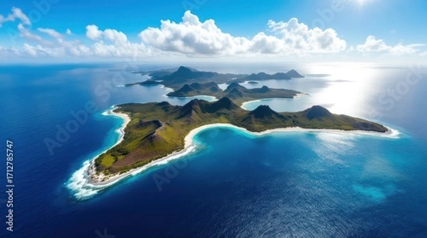 Fototapeta Stunning aerial view of an isolated tropical island surrounded by crystal clear waters and lush green hills