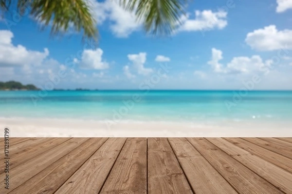 Fototapeta Blurred serene ocean backdrop with wooden deck in the foreground on the horizon of a sandy tropical shore; peaceful outdoor getaway with a blissful mindset overlooking a resort patio under sunny