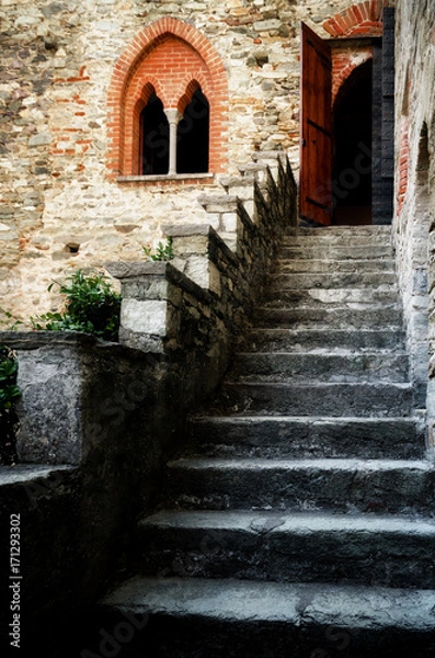 Fototapeta Antique castle staircase with double lancet window and entrance door at the top