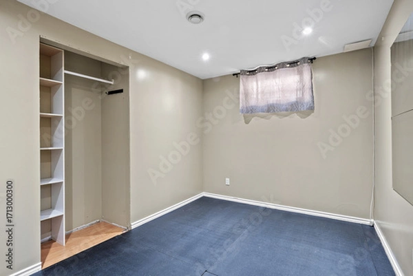 Fototapeta Small, empty room with a window and a closet