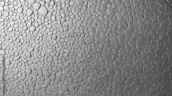 Fototapeta Close-up of water droplets on a textured surface, creating an abstract pattern in shades of gray.