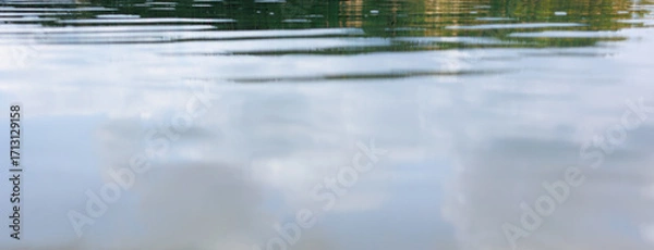 Fototapeta Calm lake water with reflections of sky and trees