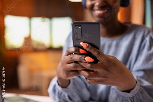 Fototapeta Close up of woman entrepreneur using cellphone at desk, communicating with colleagues from comfort of home. Happy female individual browsing social media, replying to texts during remote work break.