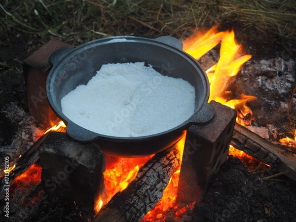 Fototapeta fire in a fireplace The first firing of the cauldron over an open fire with table salt