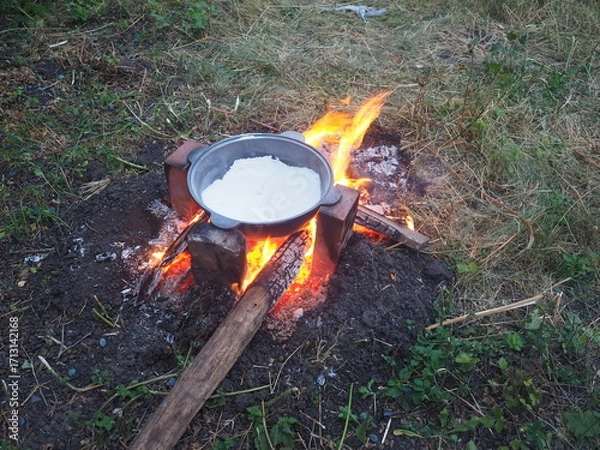 Fototapeta campfire in the forest The first firing of the cauldron over an open fire with table salt