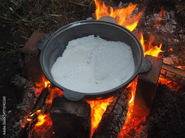 Fototapeta fire in a pot The first firing of the cauldron over an open fire with table salt