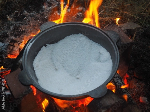 Fototapeta kettle on fire The first firing of the cauldron over an open fire with table salt