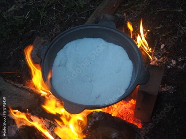 Fototapeta fire in a fireplace The first firing of the cauldron over an open fire with table salt
