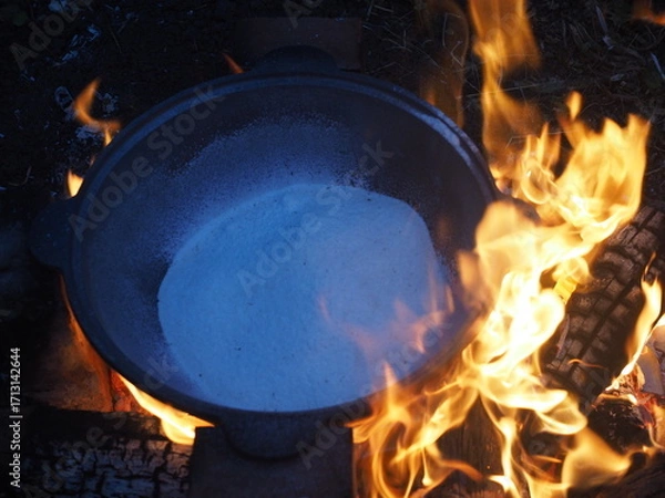 Fototapeta kettle on fire The first firing of the cauldron over an open fire with table salt