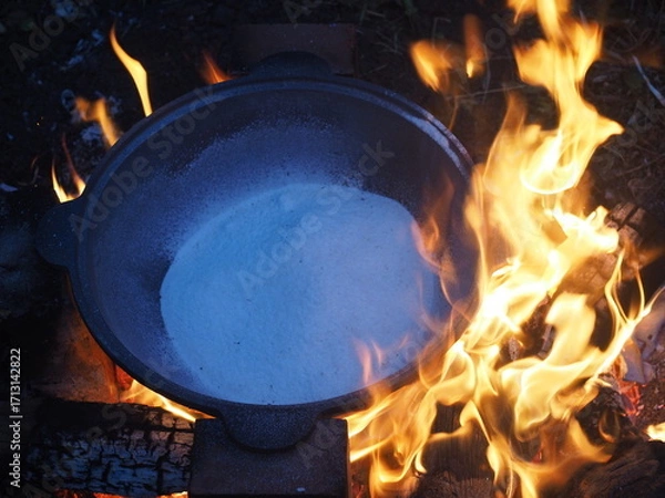 Fototapeta fire in a fireplace The first firing of the cauldron over an open fire with table salt