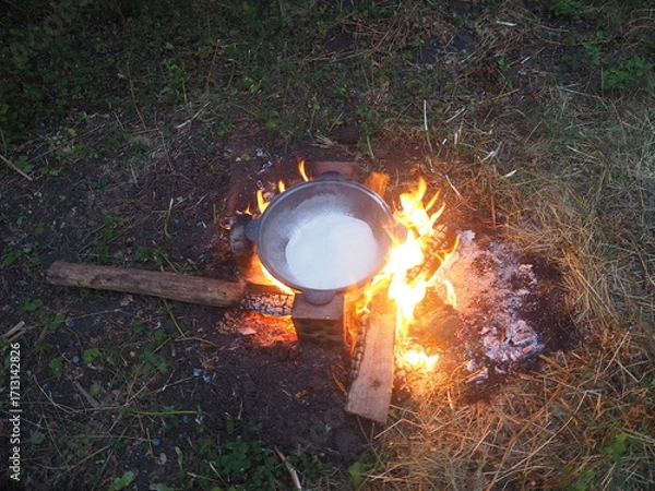 Fototapeta campfire in the forest The first firing of the cauldron over an open fire with table salt