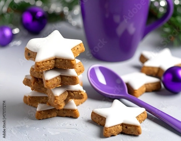 Fototapeta Stack of star-shaped iced cookies on a light gray surface, with a purple mug and spoon. Christmas decorations are in the background