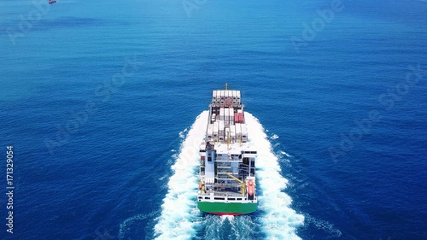 Obraz a medum container ship sails on open water fully loaded with containers and cargo