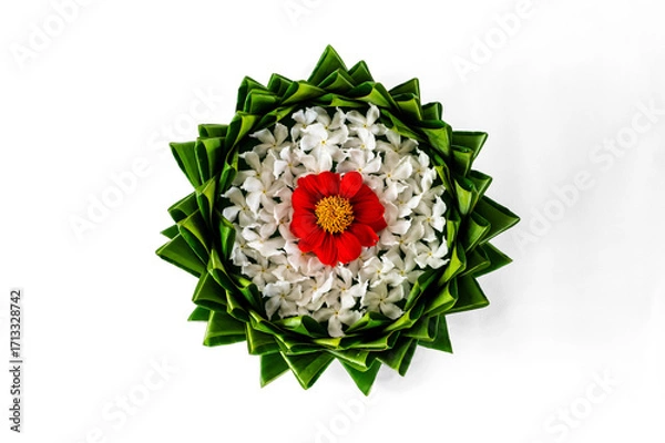 Fototapeta Top view of banana leaf Krathong decorates with colorful flowers for Thailand full moon or Loy Krathong festival isolated on white paper background.
