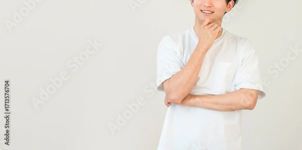 Fototapeta 頬杖をつく笑顔の若いアジア人男性（想像,思い出,思い浮かぶ,アイデア,将来,夢,妄想）
