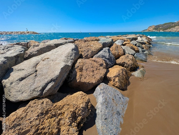 Fototapeta Espigón de rocas en una playa